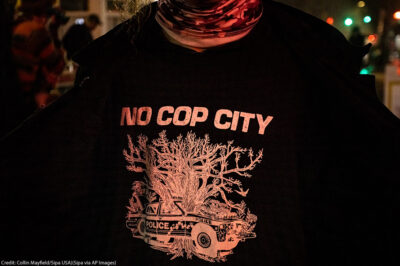 A protestor wearing a t shirt that says No Cop City.