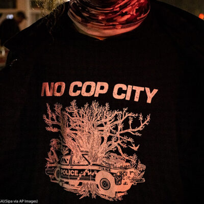 A protestor wearing a t shirt that says No Cop City.