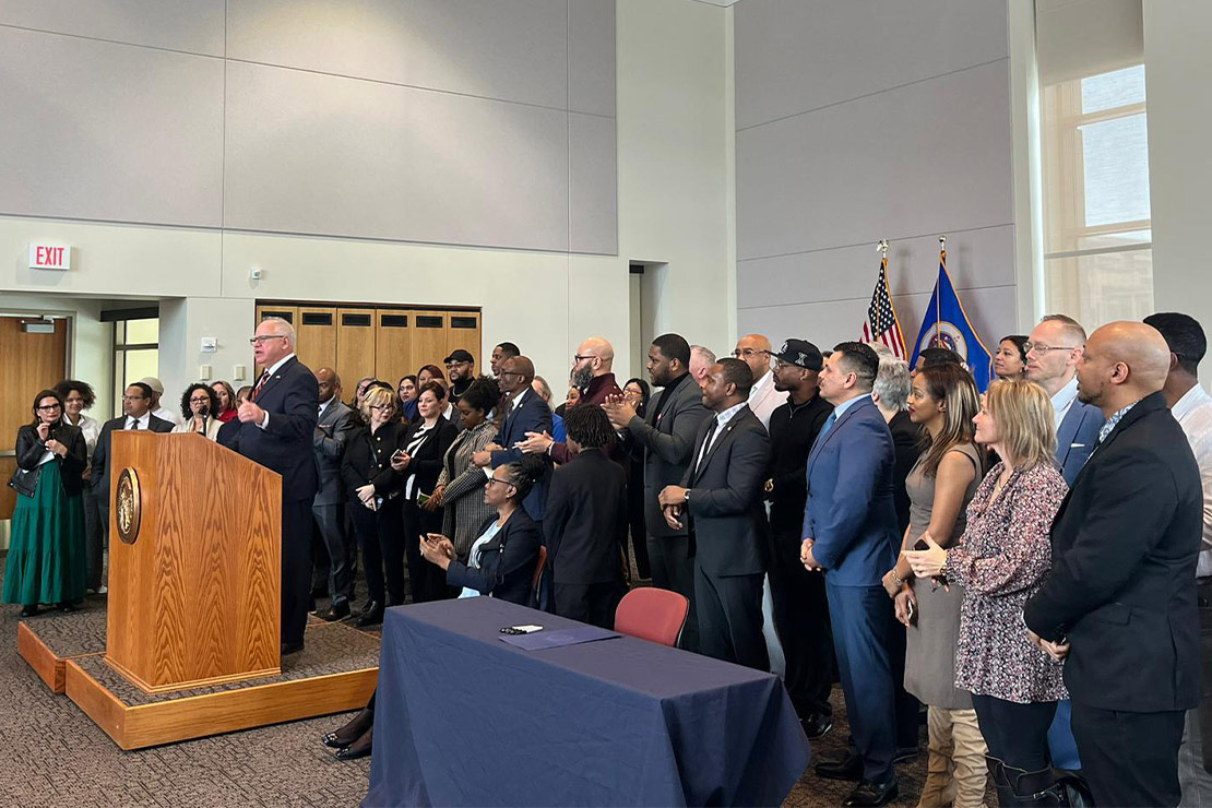 Jennifer Schroeder and other clients and activists visited the Minnesota Department of Revenue to watch Gov. Tim Walz sign House File 28 into law in March 2023.