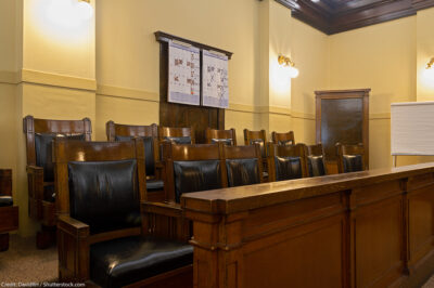 An empty jury box with leather and wood chairs.