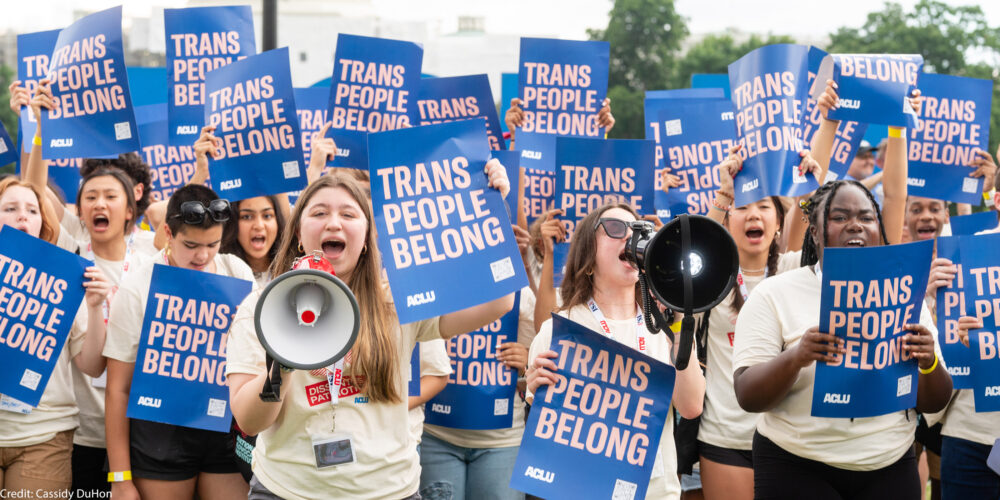 A group of young demonstrators holding ACLU signs that say Trans People Belong.