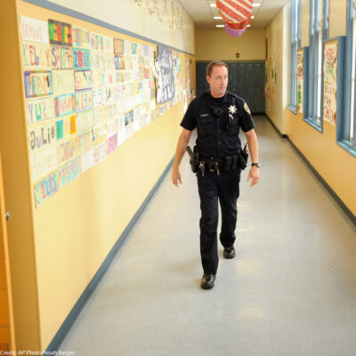 In this Dec. 17, 2012 photo, Officer Rick Moore of the Oakland school district police patrols Oakland Technical High School in Oakland, Calif.