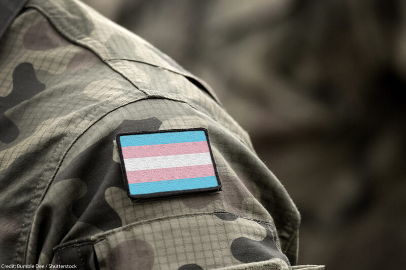 Transgender Pride flag on shoulder of a military camouflage uniform.