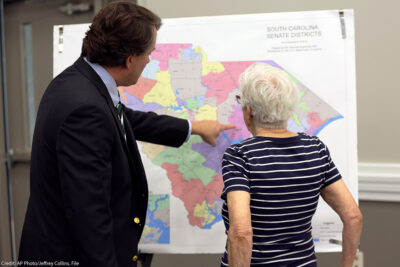 People look over the current South Carolina Senate districts at a public meeting.