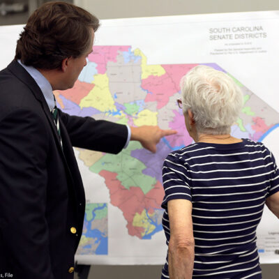 People look over the current South Carolina Senate districts at a public meeting.