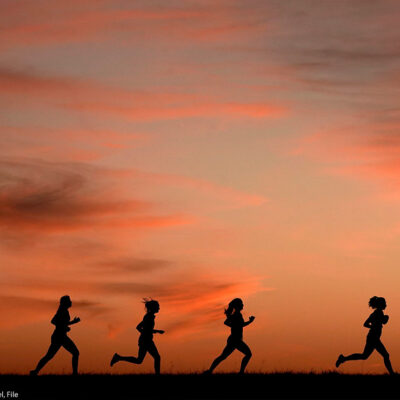 A silhouette of a line of runners.