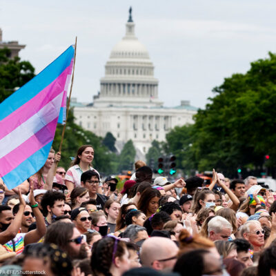 Trans flag flown at Capital Pride parade in Washington, DC, with the US Capitol in the background.