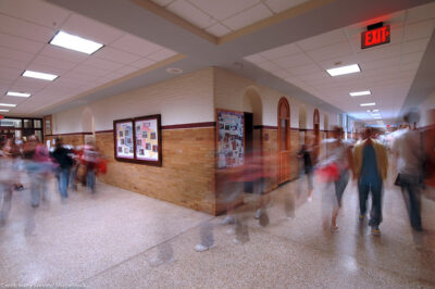 A group of kids moving in a school hallway.